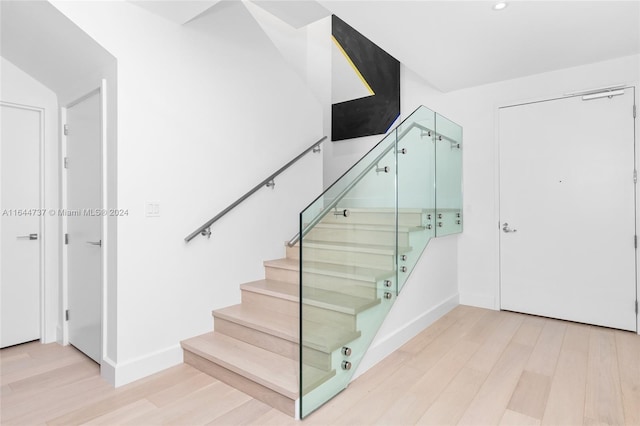 stairway with baseboards, recessed lighting, and wood finished floors