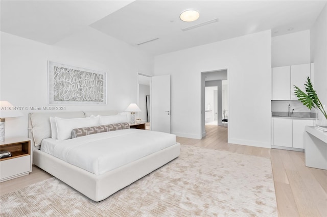 bedroom with light hardwood / wood-style flooring and sink