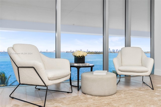 sitting room featuring a water view and wood finished floors