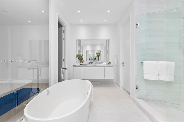 bathroom with tile patterned flooring, vanity, recessed lighting, a freestanding tub, and a stall shower