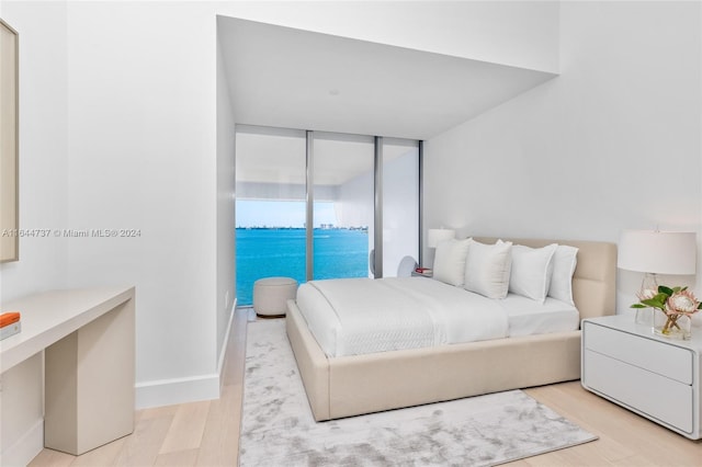 bedroom featuring baseboards and light wood finished floors