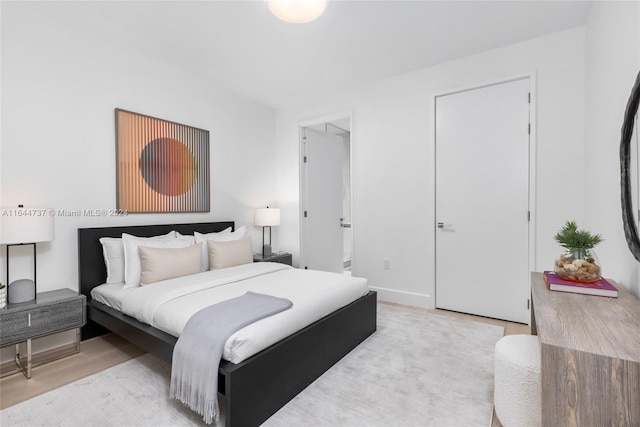 bedroom featuring baseboards and light wood finished floors