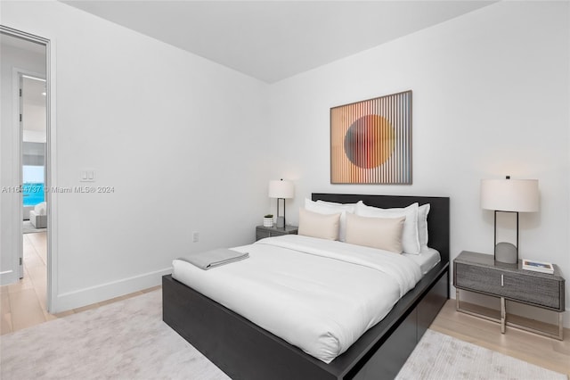 bedroom featuring light wood-style floors and baseboards
