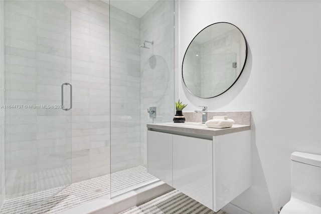 bathroom featuring an enclosed shower, toilet, and vanity