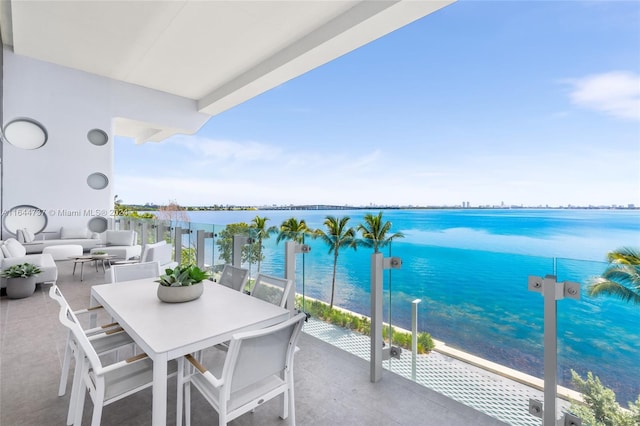 balcony featuring a water view, outdoor dining area, and an outdoor hangout area