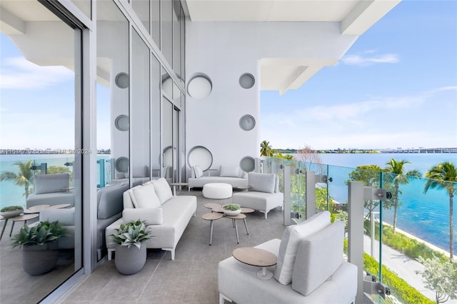 balcony featuring a water view and an outdoor living space
