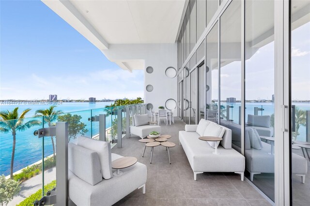 balcony with a water view and an outdoor hangout area