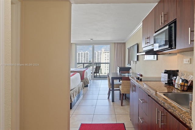 kitchen with black appliances, light tile patterned floors, and ornamental molding