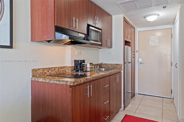 kitchen with dark stone countertops, light tile patterned floors, appliances with stainless steel finishes, sink, and extractor fan