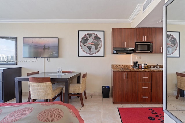 tiled dining space featuring crown molding