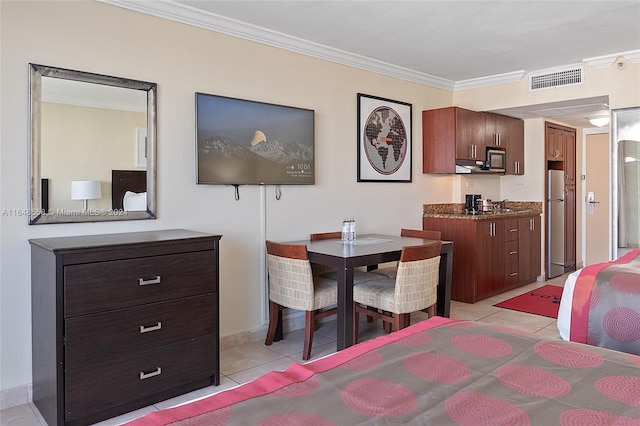 bedroom featuring visible vents, baseboards, freestanding refrigerator, crown molding, and light tile patterned floors
