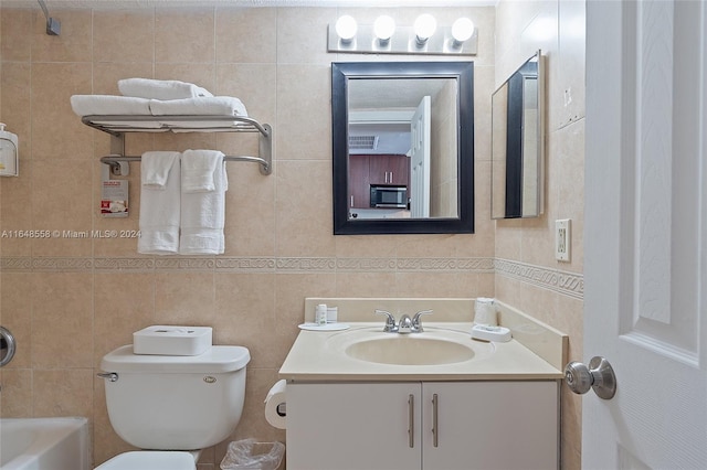 full bathroom featuring vanity, toilet, and tile walls