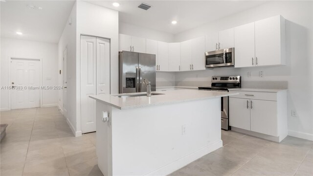 kitchen featuring a kitchen island with sink, appliances with stainless steel finishes, sink, and white cabinets