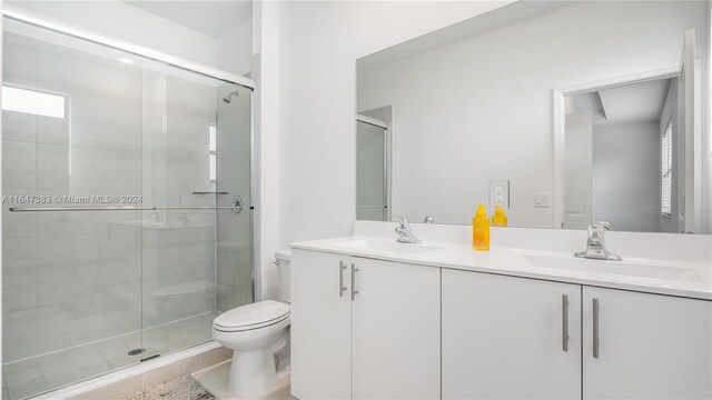 bathroom with tile patterned floors, toilet, walk in shower, and vanity