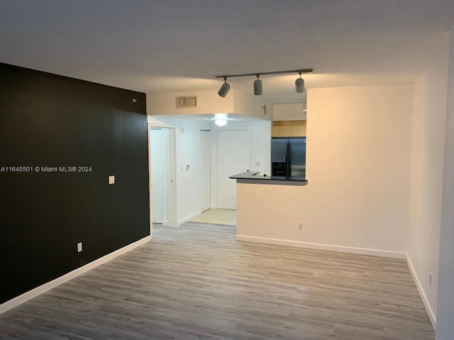 empty room with rail lighting and hardwood / wood-style flooring