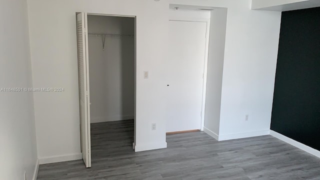 unfurnished bedroom with a closet and dark hardwood / wood-style floors