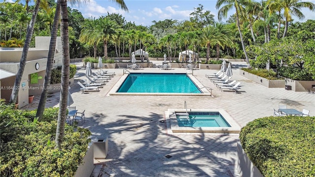 pool featuring a hot tub and a patio