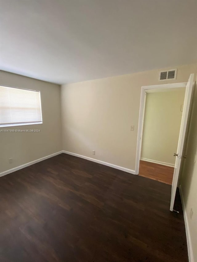 unfurnished room featuring dark wood-type flooring