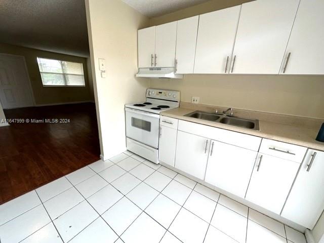 kitchen with sink, light hardwood / wood-style flooring, white electric stove, and white cabinets