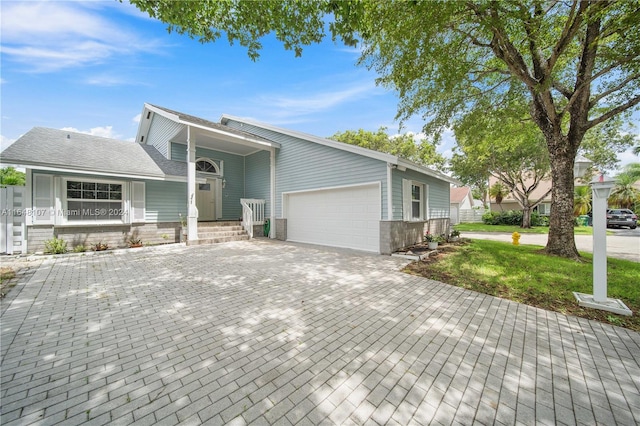 view of front facade with a front lawn, decorative driveway, and an attached garage