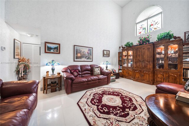 tiled living room with high vaulted ceiling and a textured ceiling