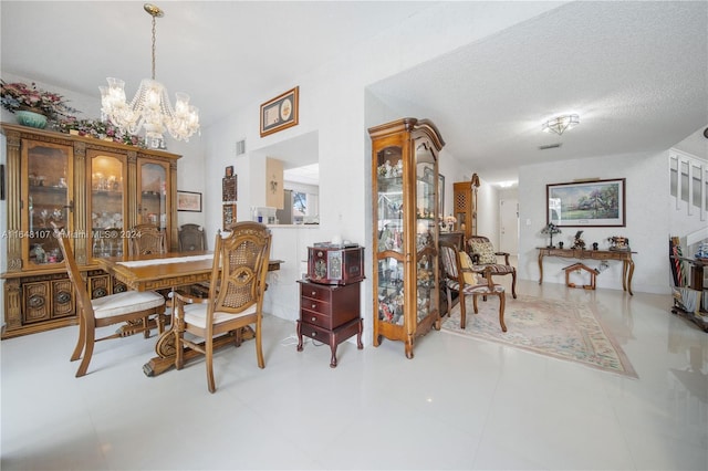 dining area featuring an inviting chandelier, visible vents, and a textured ceiling