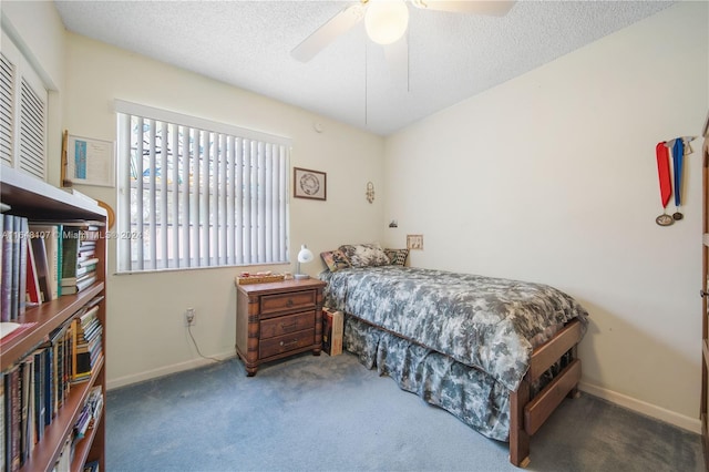 bedroom with a ceiling fan, dark carpet, a textured ceiling, and baseboards