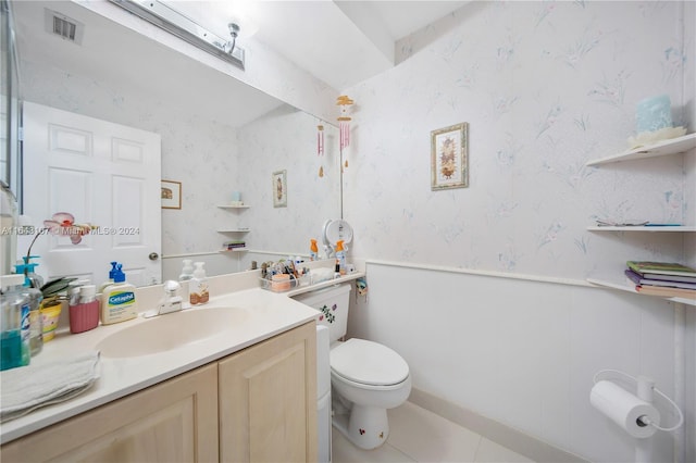 bathroom featuring toilet, vanity, visible vents, wainscoting, and wallpapered walls