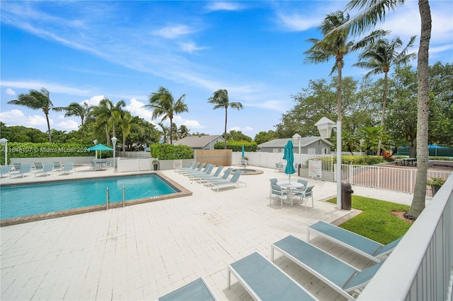 pool with a patio and fence