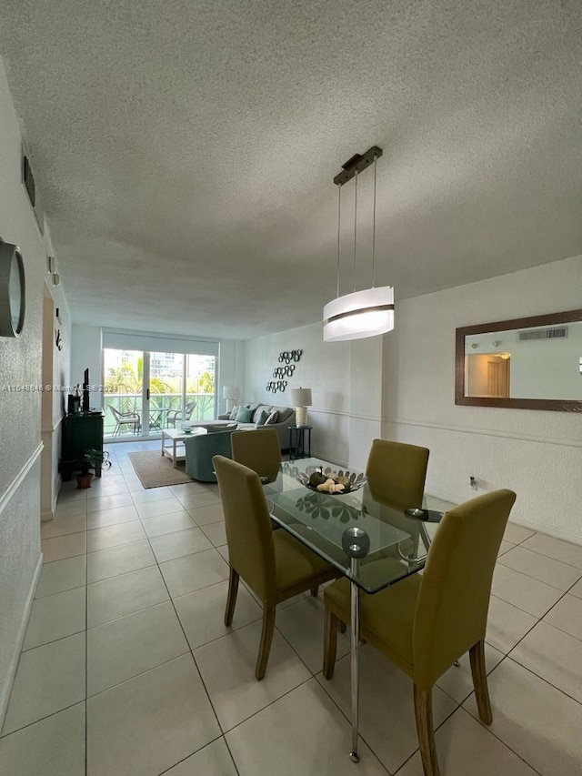 dining room featuring light tile patterned floors and a textured ceiling