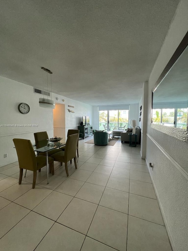 tiled dining space with a textured ceiling