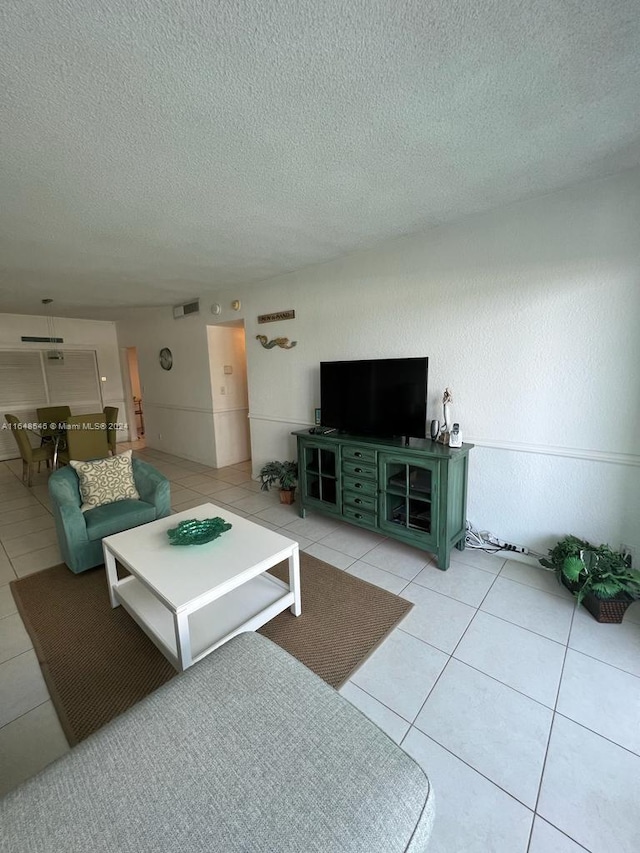 tiled living room featuring a textured ceiling