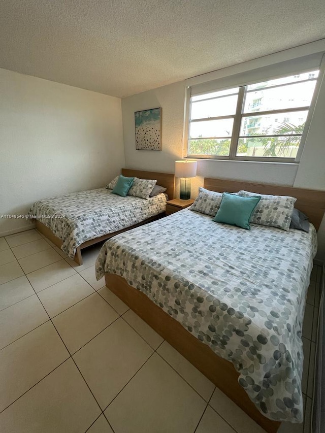 tiled bedroom featuring a textured ceiling