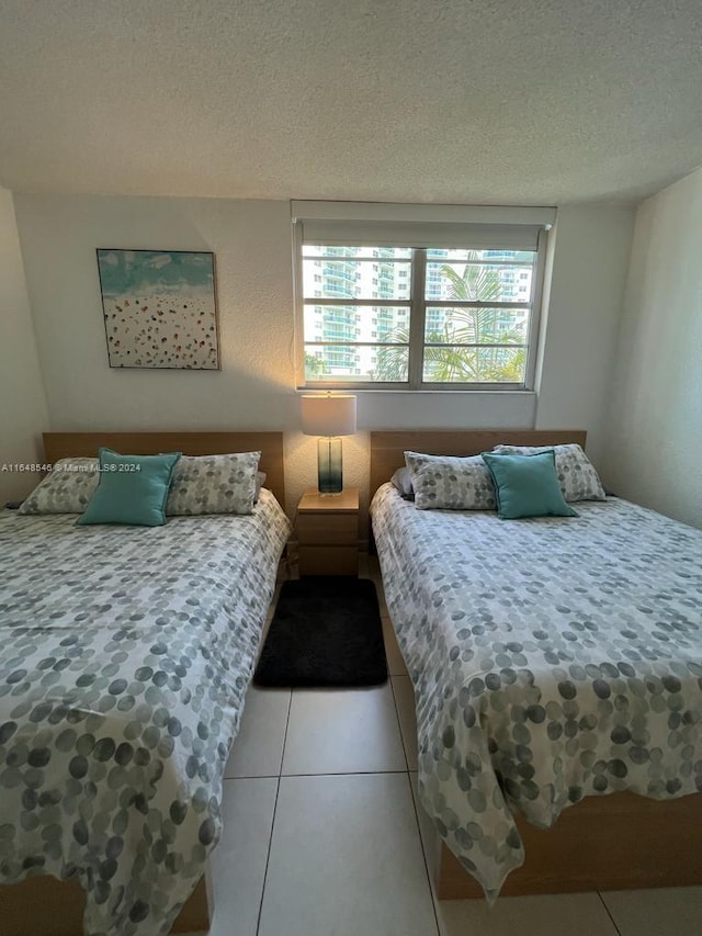 tiled bedroom with a textured ceiling