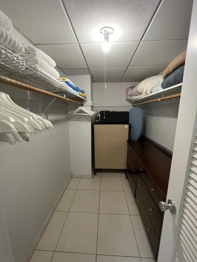 spacious closet with light tile patterned floors and a paneled ceiling