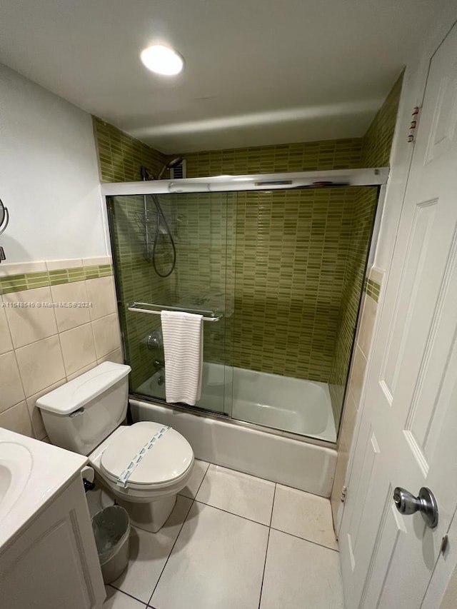 full bathroom with vanity, enclosed tub / shower combo, tile patterned floors, tile walls, and toilet