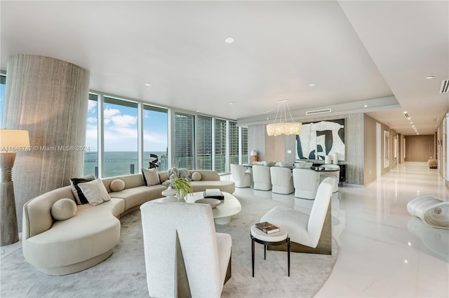 living room featuring floor to ceiling windows, a water view, and a notable chandelier