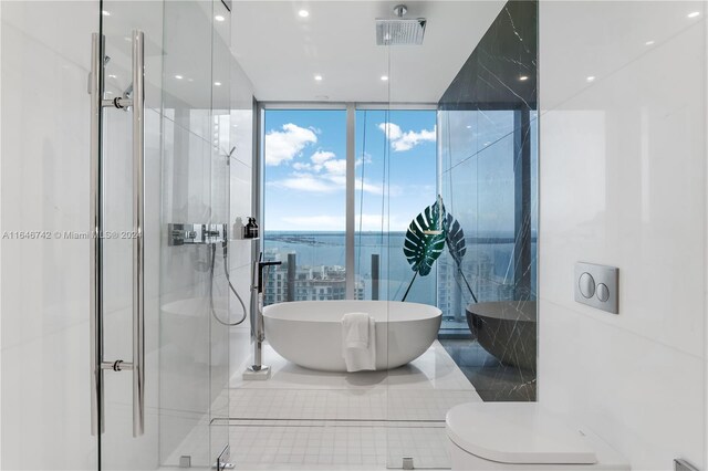 bathroom featuring a wall of windows and shower with separate bathtub