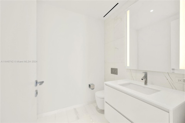 bathroom featuring tile patterned flooring, vanity, and toilet