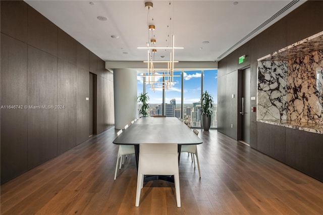 dining area with dark hardwood / wood-style flooring, expansive windows, and a notable chandelier