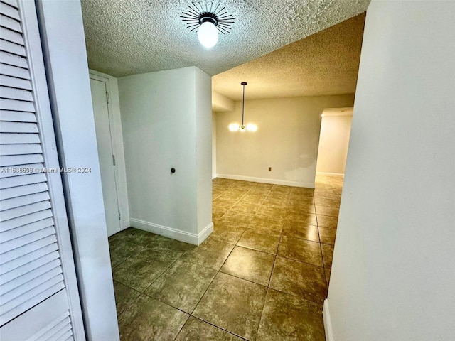 interior space with an inviting chandelier and a textured ceiling