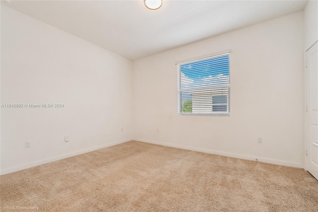 carpeted empty room with baseboards