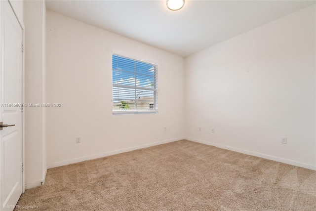 empty room featuring carpet flooring and baseboards