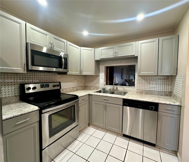 kitchen featuring sink, stainless steel appliances, decorative backsplash, and light tile patterned floors