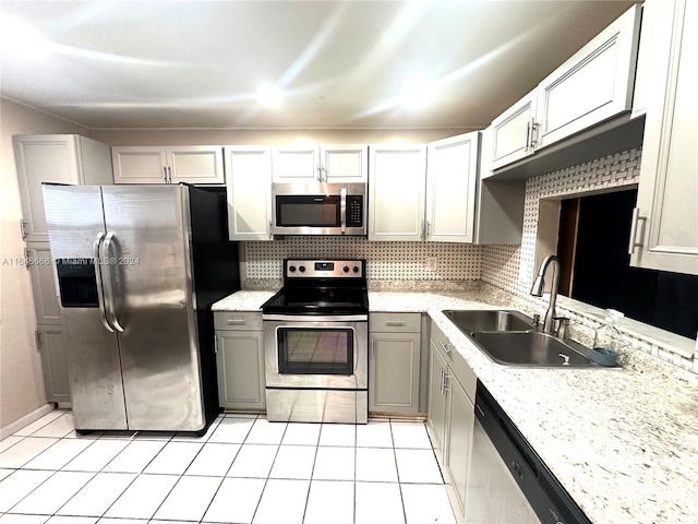 kitchen with light tile patterned floors, appliances with stainless steel finishes, sink, and gray cabinetry