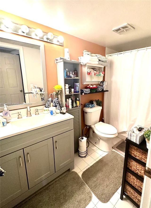 bathroom with toilet, vanity, walk in shower, and tile patterned floors