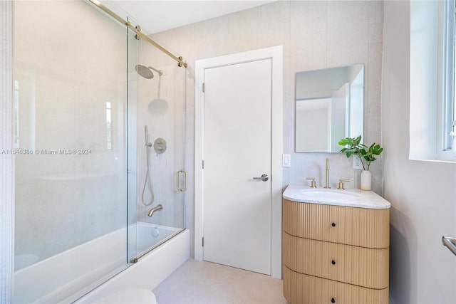 bathroom with vanity, tile walls, and enclosed tub / shower combo