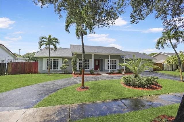 ranch-style home featuring a front yard and covered porch