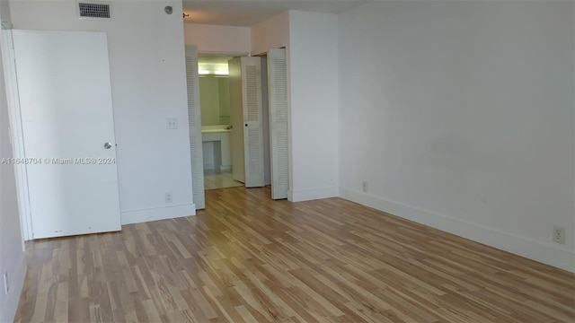 unfurnished bedroom featuring light hardwood / wood-style flooring and ensuite bath