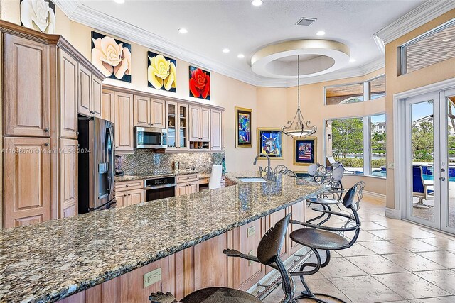 kitchen with a kitchen breakfast bar, stainless steel appliances, sink, and french doors